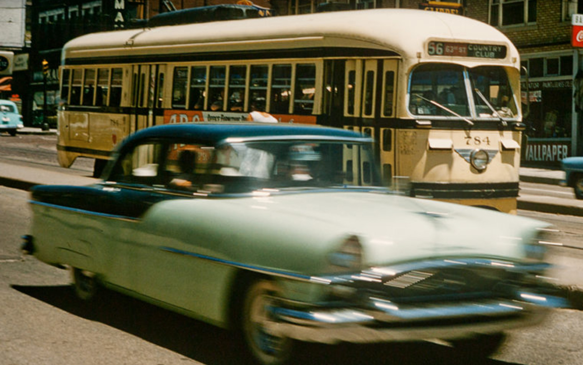 A yellow streetcar passes cars on a Kansas City street in the 1950s.